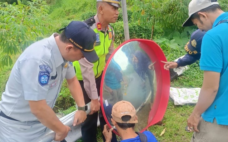 Petugas gabungan sedang memasang convex mirror di salah satu titik rawan kecelakaan di jalur kawasan wisata Tawangmangu.