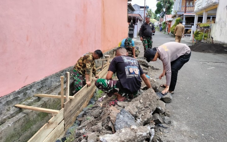 Satgas TMMD Kodim 1310/Bitung bersama warga saat memperbaiki saluran air yang melintas di pemukiman warga