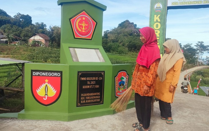 "Dua warga Bandardawung sedang melihat Tugu Prasasti TMMD Reguler ke-126 tahun 2025 Kodim 0727/Karanganyar, di desa Bandardawung kecamatan Tawangmangu kabupaten Karanganyar"
