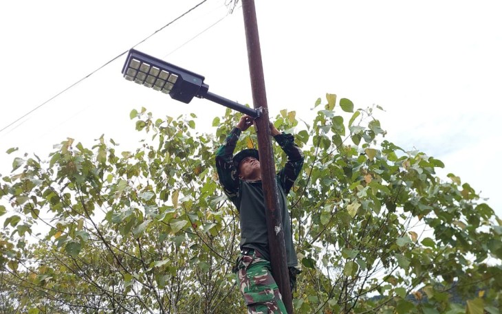 Prajurit TNI Pasang Lampu Tenaga Surya