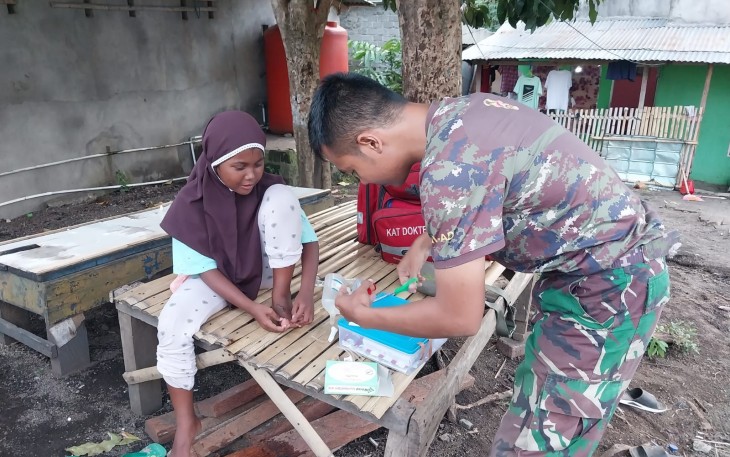 Tim kesehatan satgas TMMD Ke-123 Kodim 1310/Bitung saat memberikan pertolongan pertama pada seorang anak yang mengalami kecelakaan saat bermain