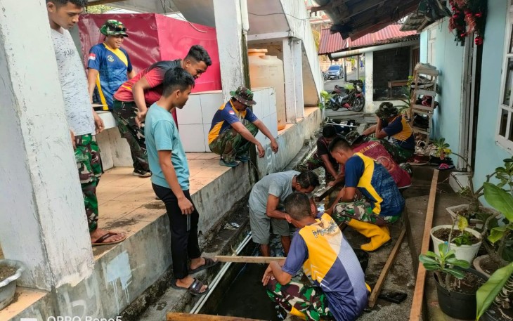 Personel Satgas TMMD Kodim 1310/Bitung bersama warga saat menggelar Karya bakti bersih-bersih lingkungan pasar dan perbaikan saluran air
