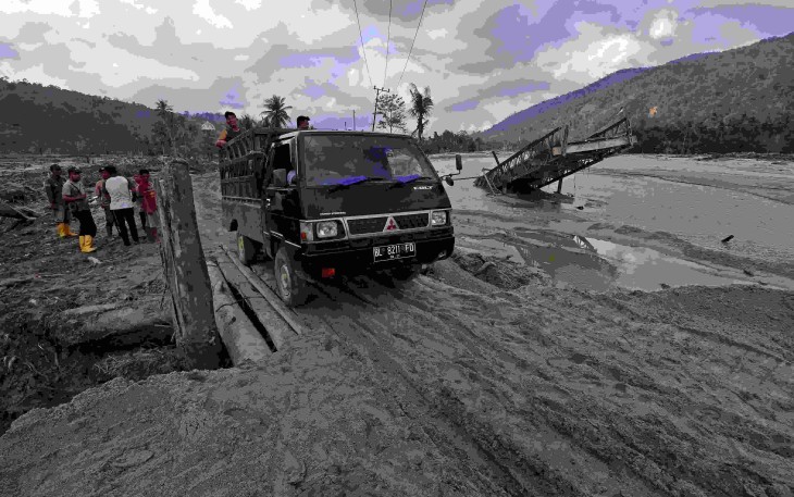 Sejumlah kendaraan melewati jembatan darurat yang dibangun untuk kembali menghubungkan akses jalur provinsi Aceh Timur-Gayo Lues, di kilometer 83 Peureulak-Lokop pascabanjir bandang di Gampong Lokop, Kecamatan Serbajadi, Kabupaten Aceh Timur, Provinsi Aceh, Sabtu (10/1).
