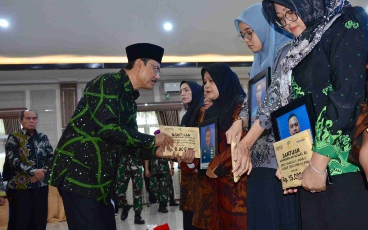 Mensos Saifullah Yusuf menyerahkan santunan duka ahli waris prajurit TNI AL korban longsor Cisarua di Jakarta, Selasa (10/2)