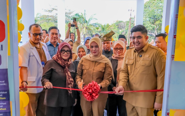 Pemotongan pita sebagai simbol dimulainya operasional fasilitas pelayanan kesehatan baru.