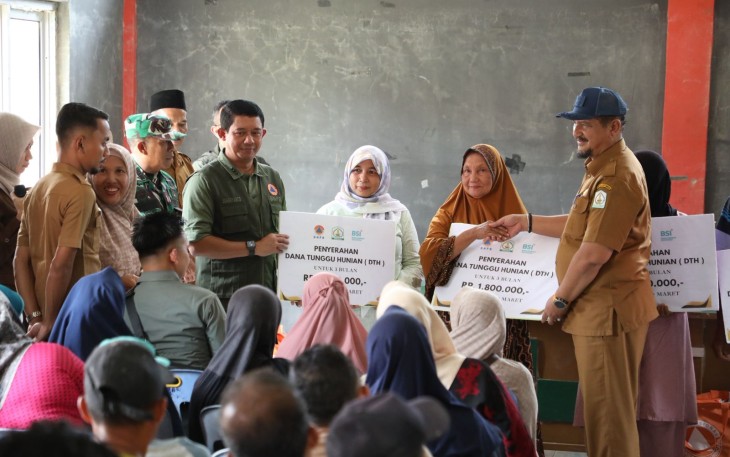 Kepala BNPB Letjen TNI Dr. Suharyanto, S.Sos., M.M (baju rompi hijau ) dan Bupati Aceh Tamiang  Armia Pahmi saat menyerahkan bantuan dana tunggu hunian (DTH) kepada warga yang terdamapk bencana di Kecamatan Rantau , Kabupaten Aceh Tamiang, pada Selasa (10/3)