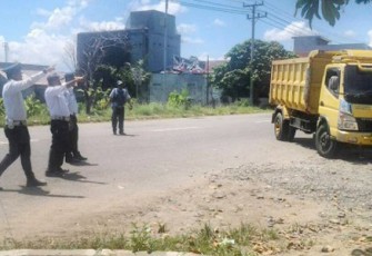 Petugas Dishub saat mengarahkan kendaraan angkutan barang untuk masuk ke Terminal Sungai Hitam, Kamis (20/4).