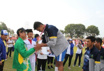 Asisten III Gotri Suyanto memberikan medali emas cabor Sepakbola kepada Kapten tim Kota Bengkulu.
