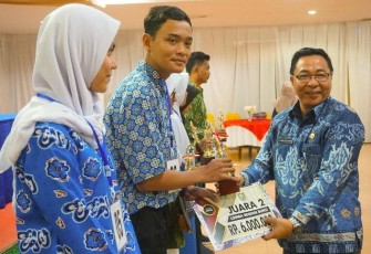Kepala Dinas Perpustakaan dan Kearsipan, Atisar Sulaiman Memberikan Hadiah Kepada Pemenang Lomba 