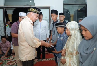 Plt. Bupati Asahan, Surya saat menyerahkan bantuan kepada anak yatim di Mesjid Nurul Hasanah