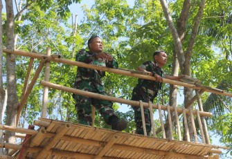 Dua Satgas TMMD Berdiri Diatas Gasebo di Atas Kolam