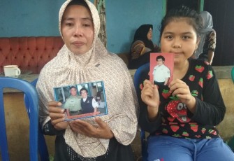 Istri dan anak korban saat menunjukan foto korban