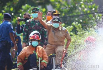 Bupati Blitar Rijanto (melambaikan tangan) saat pimpin penyemprotan Disinfektan diatas truk Damkar