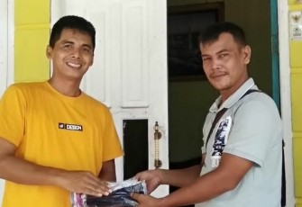 Surianto anggota DPRK Aceh Singkil (kanan) menyerahkan masker secara simbolis kepada perwakilan wartawan setempat.