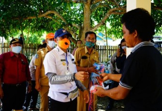 Bupati Bengkulu Selatan Gusnan Mulyadi Sedang Membagikan Masker Pada Warga 