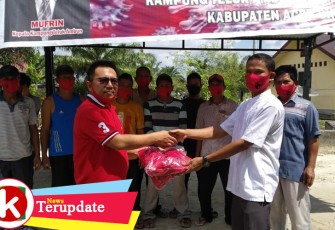 Anggota Dewan Aceh Singkil Taufik menyerahkan bantuan masker kepada Kades Teluk Ambun Mufrin di Posko Desa setempat Kecamatan Singkil.