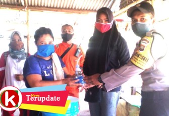 Bhabinkamtibmas saat ikut memberikan masker ke warga