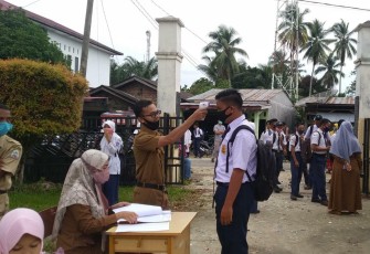Salah seorang siswa sekolah di Aceh Singkil saat menjalani tes suhu badan.