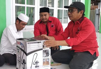 Anggota DPRK Aceh Singkil Taufik didampingi pengurus Partai PDI Perjuangan menyerahkan bantuan alat pembersih debu (vacuum cleaner).