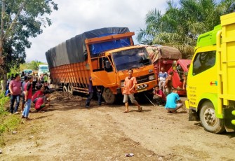 Tampak truk angkutan terjebak dijalan rusak