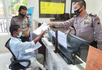 Kepala SPKT Polres Batang, Iptu Herry Rubiono memberikan formulir kepada petugasGedung Pelayanan Kepolisian, Polres Kabupaten Batang, Jumat (16/10/2020).  