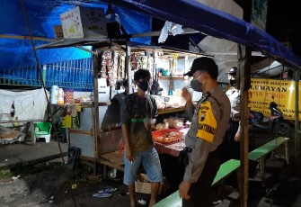 Bhabinkamtibmas Polsek Limpung Polres Batang Polda Jawa Tengah Bripka Nurhasim menyambangi pedagang kaki lima yang berjualan malam hari di sekitar alun-alun Limpung, Minggu ( 8/11/2020 ) 