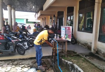 Salah Seorang Pengunjung Saat Mencuci Tangan Ditempat Yang Telah Disediakan Disdukcapil Kabupaten Aceh Singkil