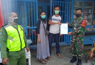 Anggota TNI dari Koramil 04/Jebres Kodim 0735/Surakarta Serka Suryanto yang saat ini menjabat sebagai Babinsa Kelurahan Sewu membantu pemulangan warganya usai melaksanakan karantina di Asrama Haji Donohudan, Sabtu (30/1/2021).