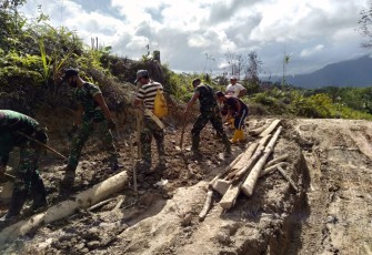 Yonif 407/PK bersama masyarakat melaksanakan gotong-royong perbaikan jalan yang dilalui warga di Desa Nanga Bayan, Kecamatan Ketungau Hulu, Kabupaten Sintang, Kalbar.