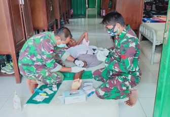 Personel Satgas Pamtas Yonif 407/PK Pos Koki Sei Beruang yang membantu mengobati Masyarakat Dusun Sei Beruang, Desa Sei Tekam, Kecamatan Sekayam, Kabupaten Sanggau, Kalimantan Barat. yang terluka akibat jatuh. Kamis (11/03/2021).