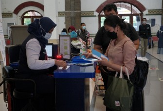 Petugas PT KAI Sedang Melayani Penumpang Kereta Api di Salah Satu Stasiun