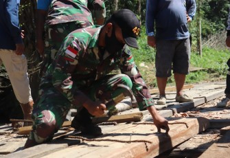Satgas Pamtas RI-MLY Yonif 407/PK bersama warga memperbaiki jembatan yang rusak di Dusun Perumbang, Desa Kekurak, Kec. Badau, Kab. Kapuas Hulu, Kalimantan Barat.