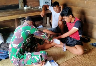 Prajurit TNI Satgas Pamtas RI-MLY Yonif 407/PK Pos Muakan memberikan pertolongan dan pengobatan kepada warga yang terluka di Desa Muakan Petinggi, Kecamatan Ketungau Hulu, Kabupaten Sintang, Kalimantan Barat. Senin (12/04/21)