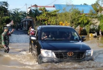 Sejumlah Desa di Gunung Mas Terendam Banjir, Babinsa Pandu Warga Sebrangi Jalan
