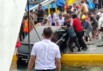 Warga bersama petugas bersama-sama mengeluarkan mobil yang jatuh ke Danau Toba