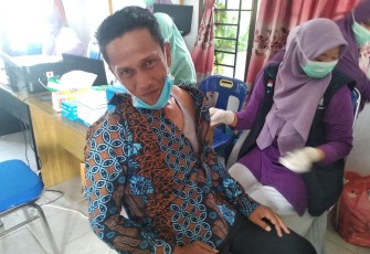 Salah seorang perangkat Desa Kilangan, Singkil saat mengikuti vaksinasi covid-19 di Desa setempat
