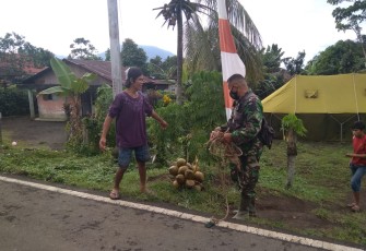 Personil satgas TMMD bersama warga usai manjat pohon kelapa