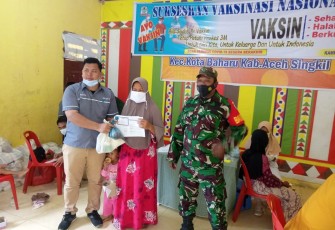 Pihak Pemdes Lentong saat memberikan bingkisan kepada warga usai mengikuti vaksinasi covid-19 didesa setempat