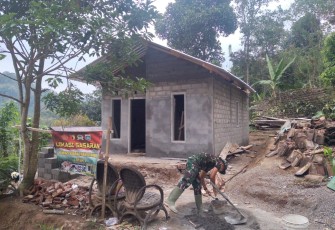 Pak TNI Mengaduk Semen Untuk Bangun Rumah Ibu Sainem
