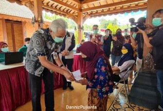 lGubernur Jawa Tengah Ganjar Pranowo saat memeriksa kartu salah satu peserta vaksin di Magelang