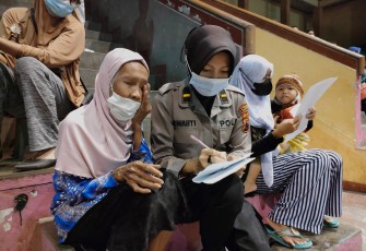 Petugas Polres Kendal Ipda Suwarti membantu Musarofah mengisi data diri saat vaksin  covid 19 di GOR Bahurekso Kendal