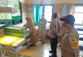 Petugas Medis Puskesmas Kepanjenkidul Kota Blitar Didampingi Polisi Saat Memeriksa Bayi yang Terbungkus Dalam Tas Ransel Warna Hitam yang Ditemukan Warga