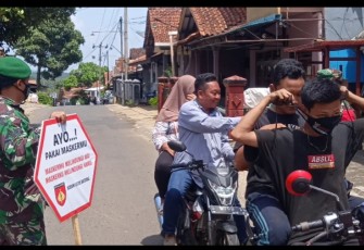 Anggota Koramil 07/Bandar Kodim 0736/Batang membagikan masker kepada para penguna jalan yang tidak mengenakan masker di Jalan Binangun Kecamatan Bandar, Kabupaten Batang, Selasa (28/9/21).