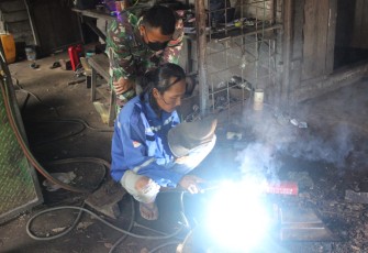 Anggota Satgas TMMD Luangkan Waktu Untuk Belajar Mengelas Bersama Bapak Kristian