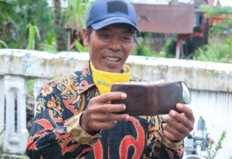 Salah Satu Warga Diberikan Dompet Milik Helmi Hasan Dan Seiisinya 