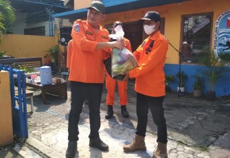 Komandan SAR Kabupaten Karanganyar, Prihanto (kiri), secara simbolis menyerahkan sumbangan paket sembako kepada perwakilan anggota relawan untuk didistribusikan kepada warga terdampak pandemi Covid-19.