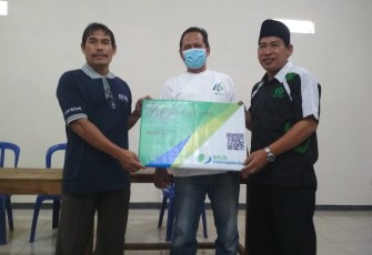 Penyerahan secara simbolis Kartu Jamsostek dari pihak BP Jamsostek Cabang Karanganyar dan LazisNU Ranting Desa Jaten kepada salah satu warga penerima di Perumahan Josroyo Jaten