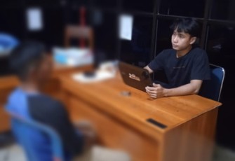 Tersangka (kaos biru) saat diperiksa penyidik
