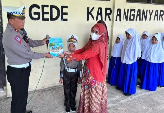  Penyerahan secara simbolis buku Pendidikan Lalu Lintas Kanit oleh Kamsel Polres Karanganyar, Ipda Teguh Sarwono kepada salah satu guru di SD Negeri 2 Tegalgede, Kabupaten Karanganyar, Kamis (25/8/2022). (Foto : Istimewa)