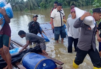 Bripka Fadli Mulyono saat turut menyalurkan bantuan Kepada Korban Banjir